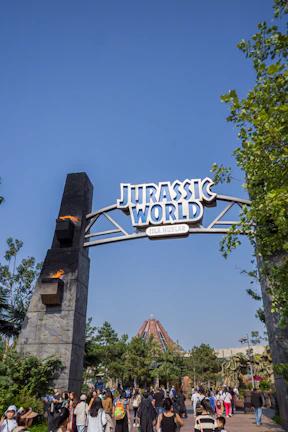 Guests enjoying the Jurassic World ride with dinosaurs roaring nearby in Universal Hollywood.
