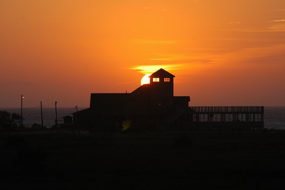 the sun is setting behind a building with a clock tower