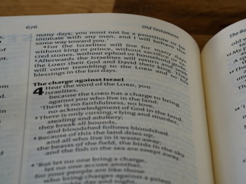 An open Bible displaying text from the Old Testament. The pages are filled with verses, and the focus is on a passage labeled 'The charge against Israel'. The page number is 676, and the left margin has dotted lines.