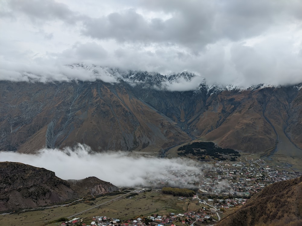 a view of a town in a valley with mountains in the background