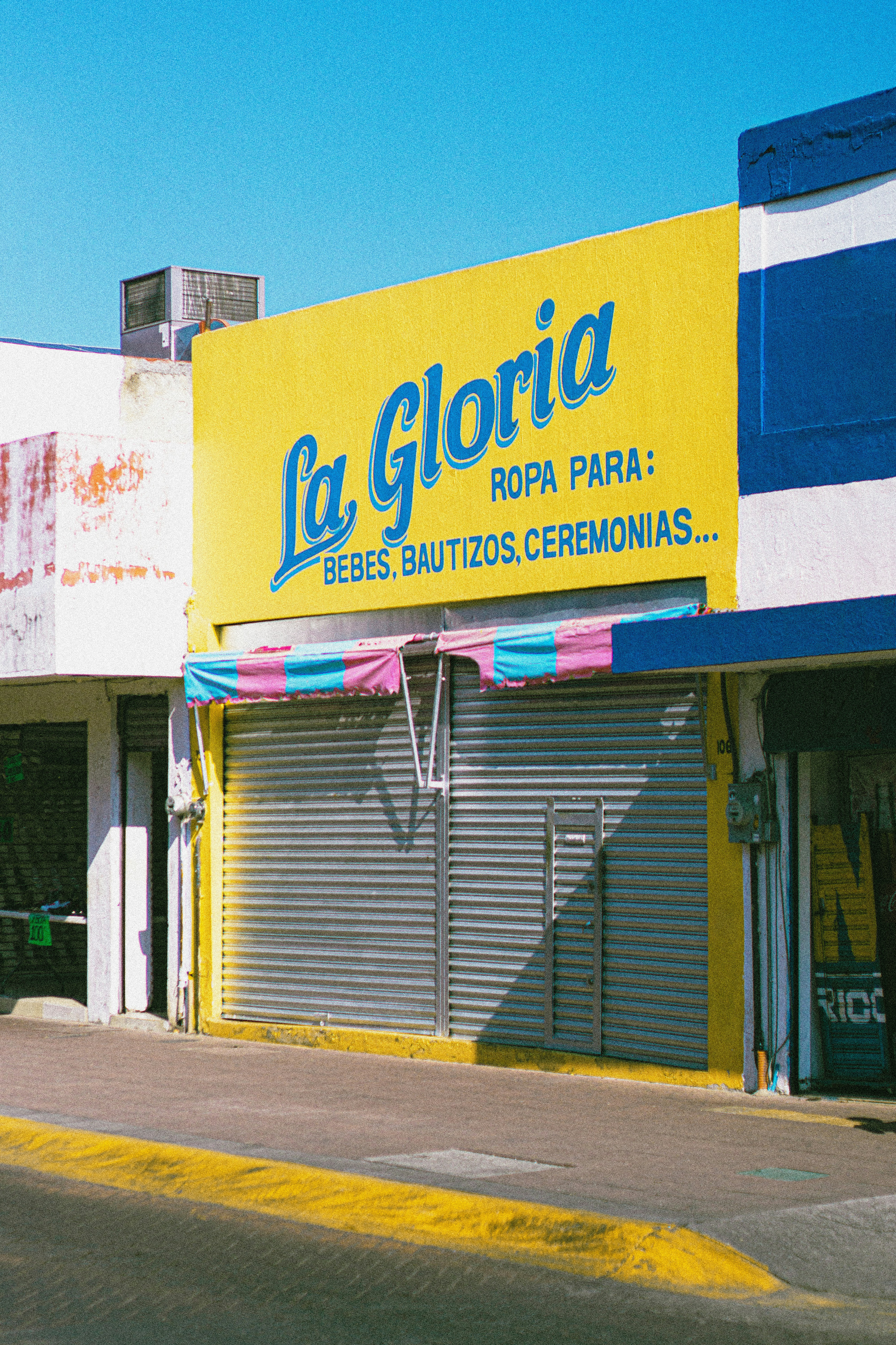 a yellow and blue store front on a city street