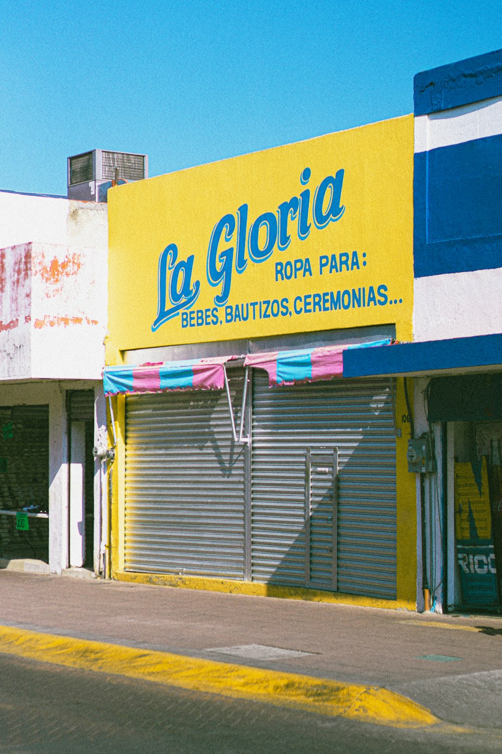 a yellow and blue store front on a city street
