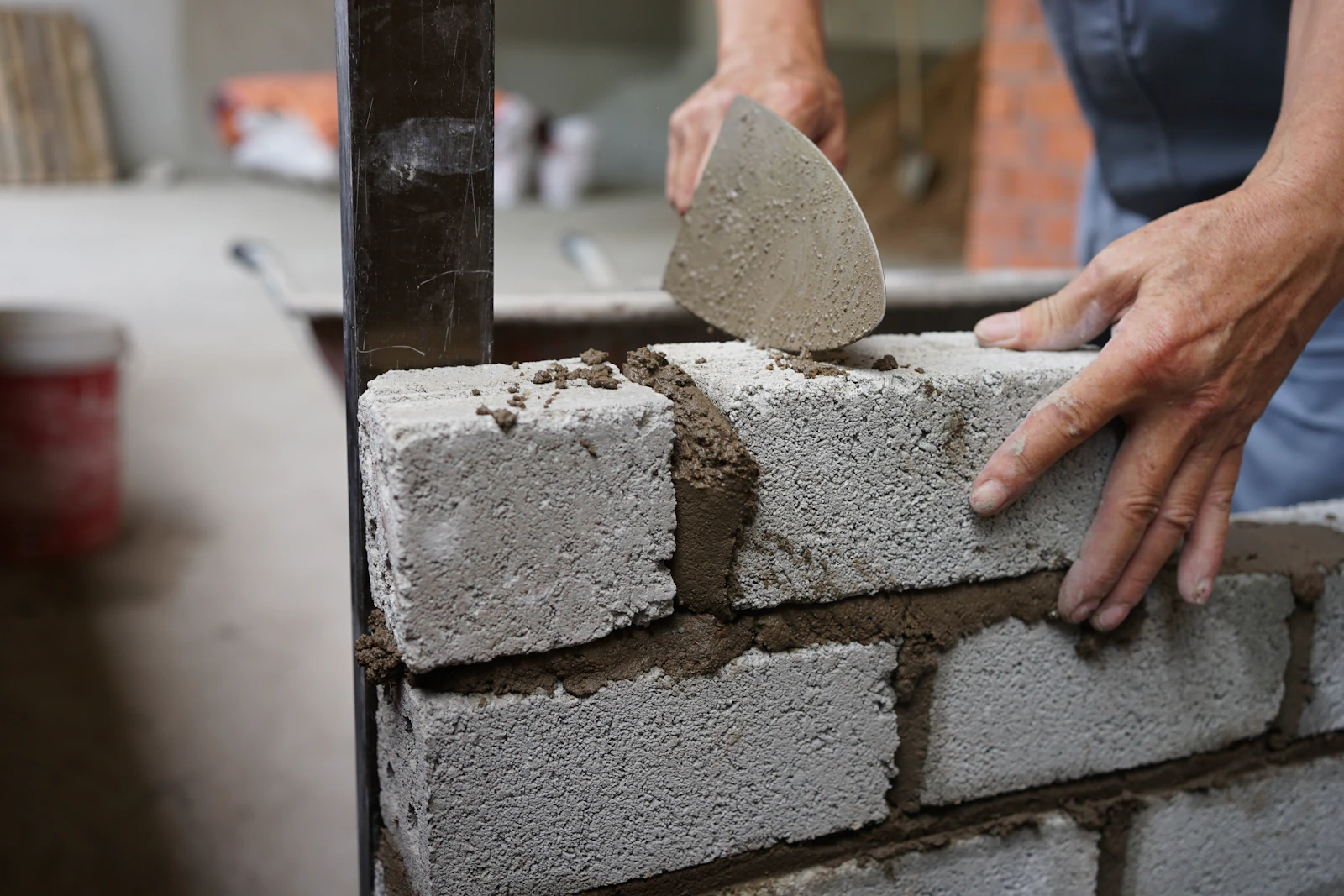 Builder laying concrete blocks with a trowel and mortar