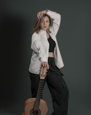 Sky Tero posing confidently with his guitar against a bold black background