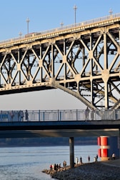 Steel bridge spanning a river with visible trusses and supports.