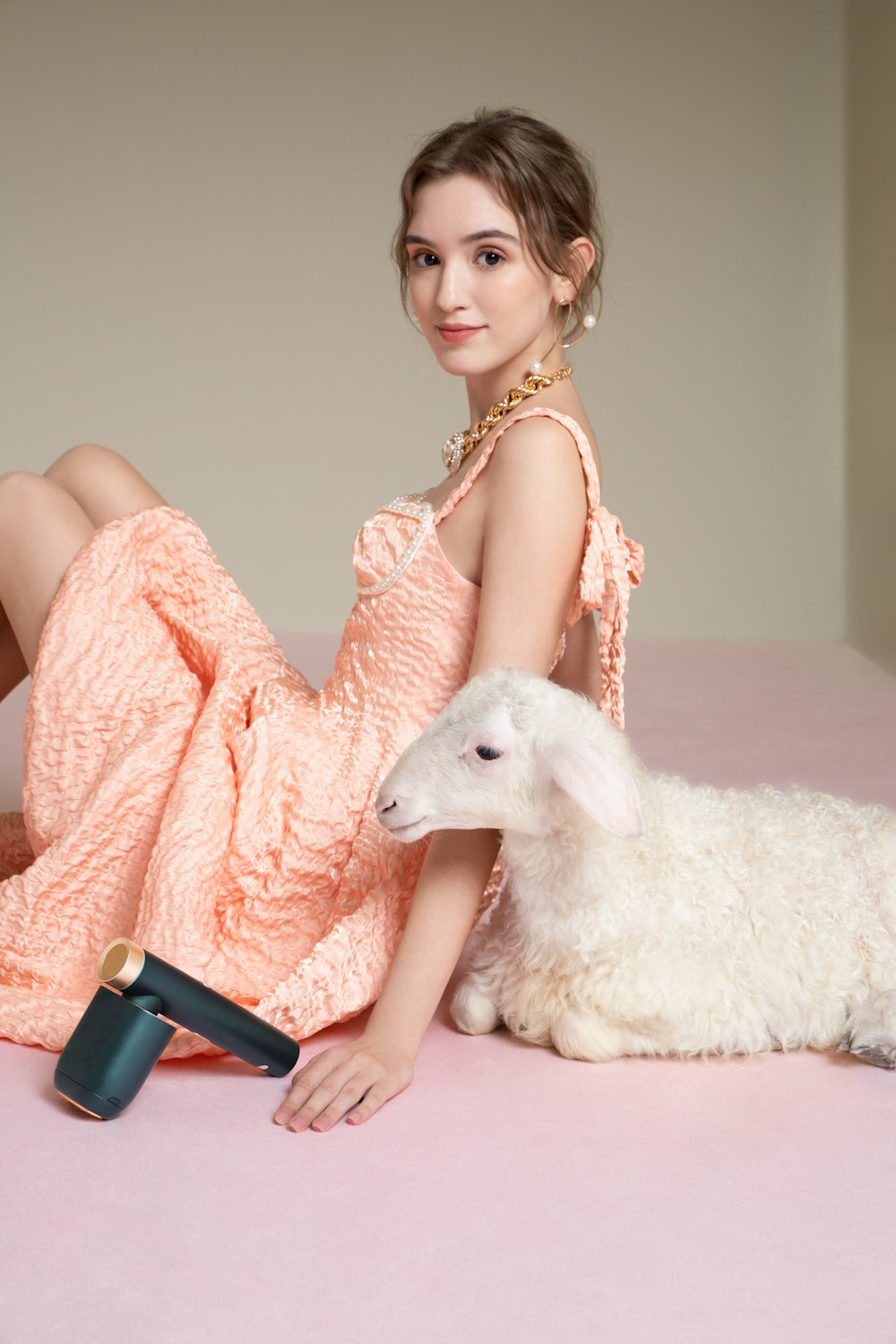 a woman sitting on a bed next to a sheep