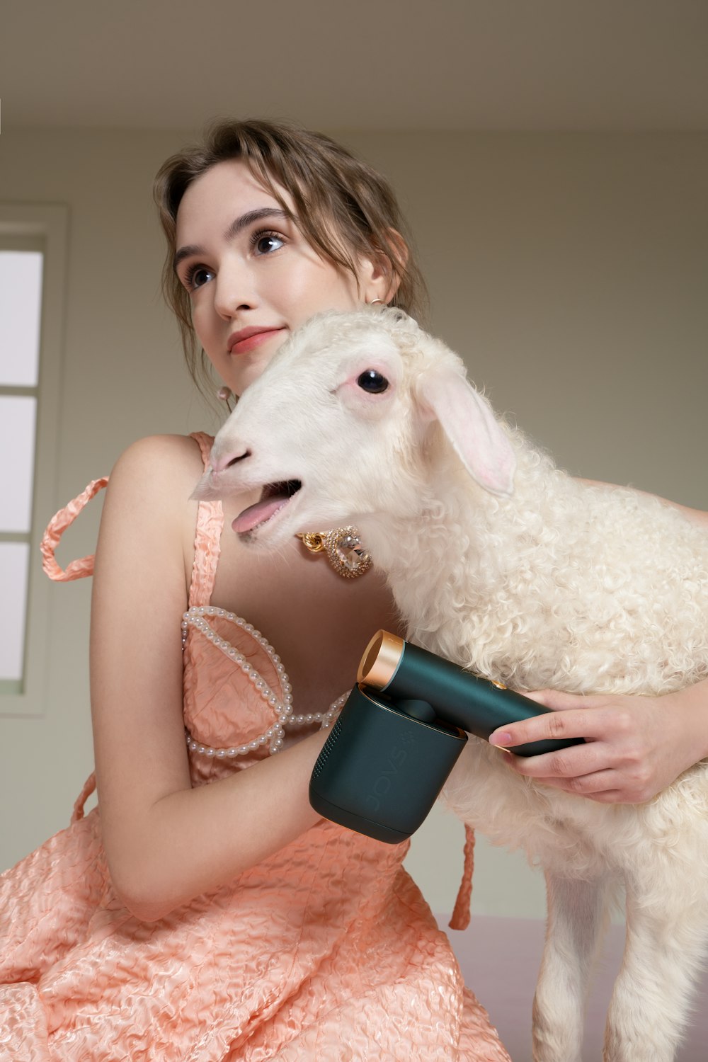 a woman in a pink dress holding a sheep