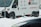A white delivery van with 'ALPI EXPRESS' branding is parked on a snowy street. Snow is falling, creating a wintry scene, and a partially buried scooter can be seen in the snow near the van.