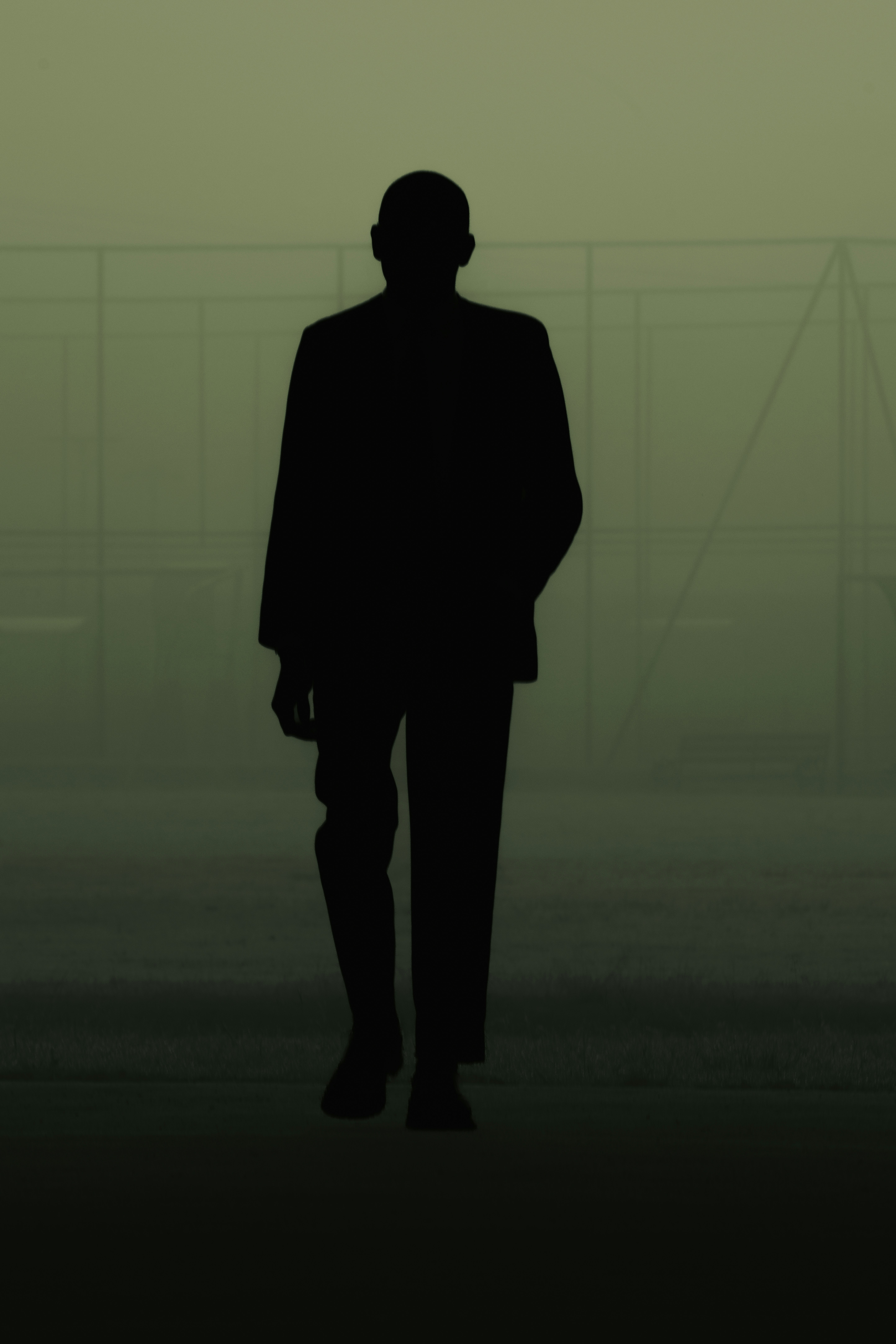 Suited executive protection professional in cinematic dark lighting