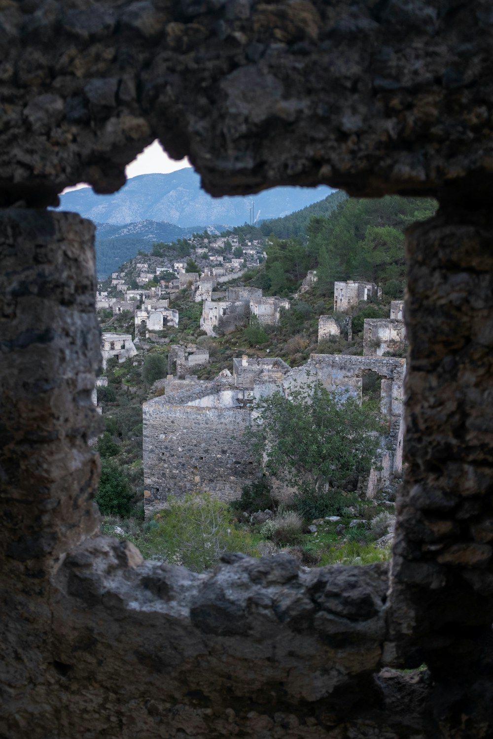 a view of a city through a hole in a stone wall