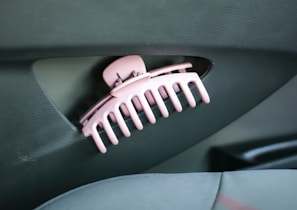The hair roller positioned next to a car seat covered with pet fur, ready to clean