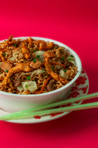 A colorful bowl of stir-fried noodles with vegetables and tender chicken.