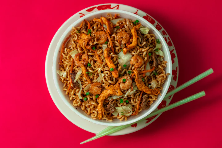 A bowl of prawn noodles and vegetables