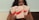 A person with long dark curly hair is holding three boxes labeled QNIX. The packages are of menstrual underwear with labels such as 'Bacoup Period Underwear' and 'High Cut Period Underwear'. The background is plain, and the person has their gaze directed away from the camera.