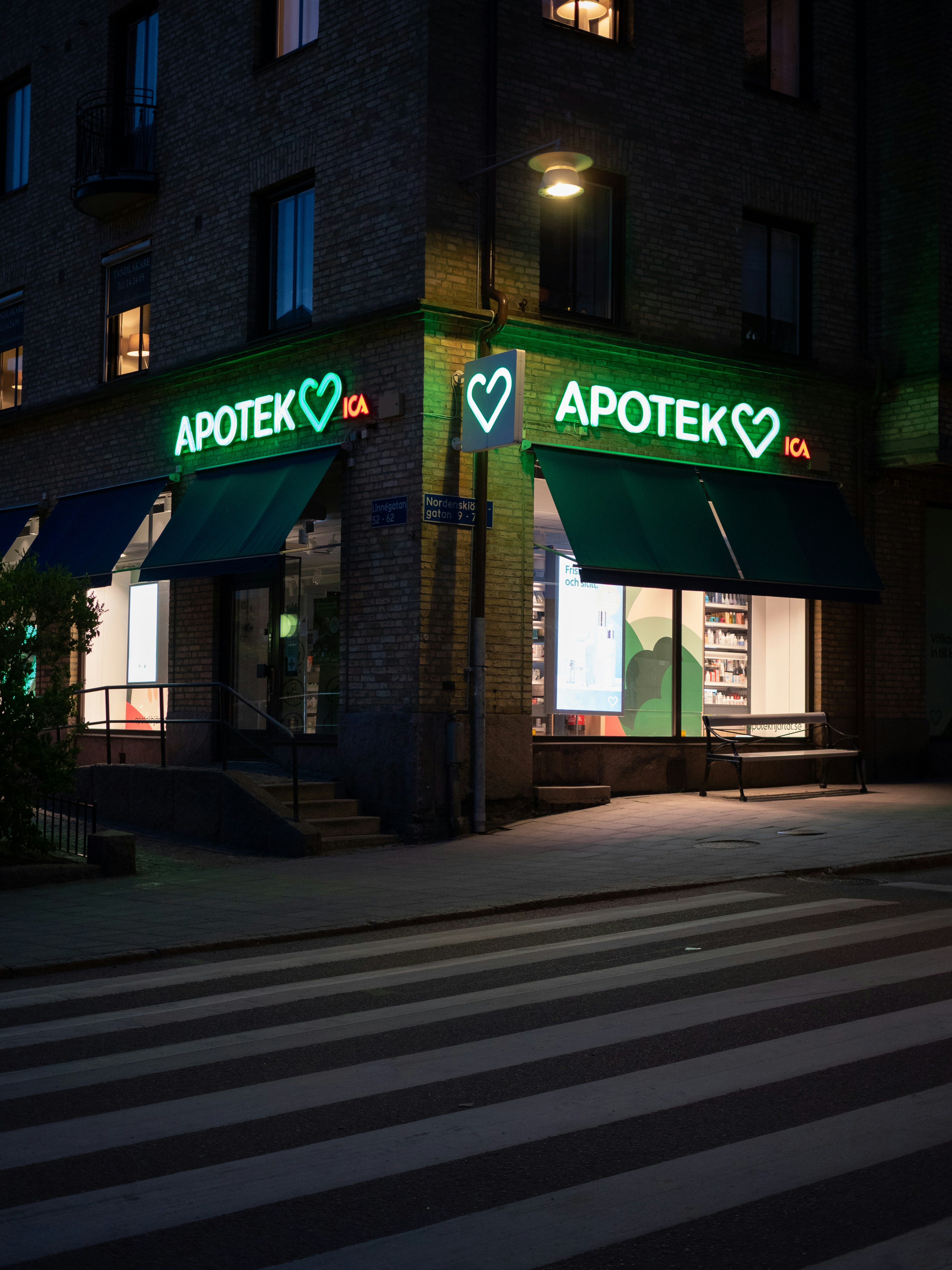 a store front with a green awning at night