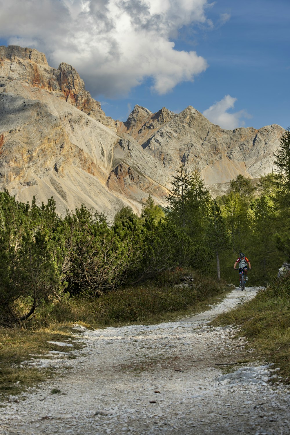 a man riding a bike down a dirt road