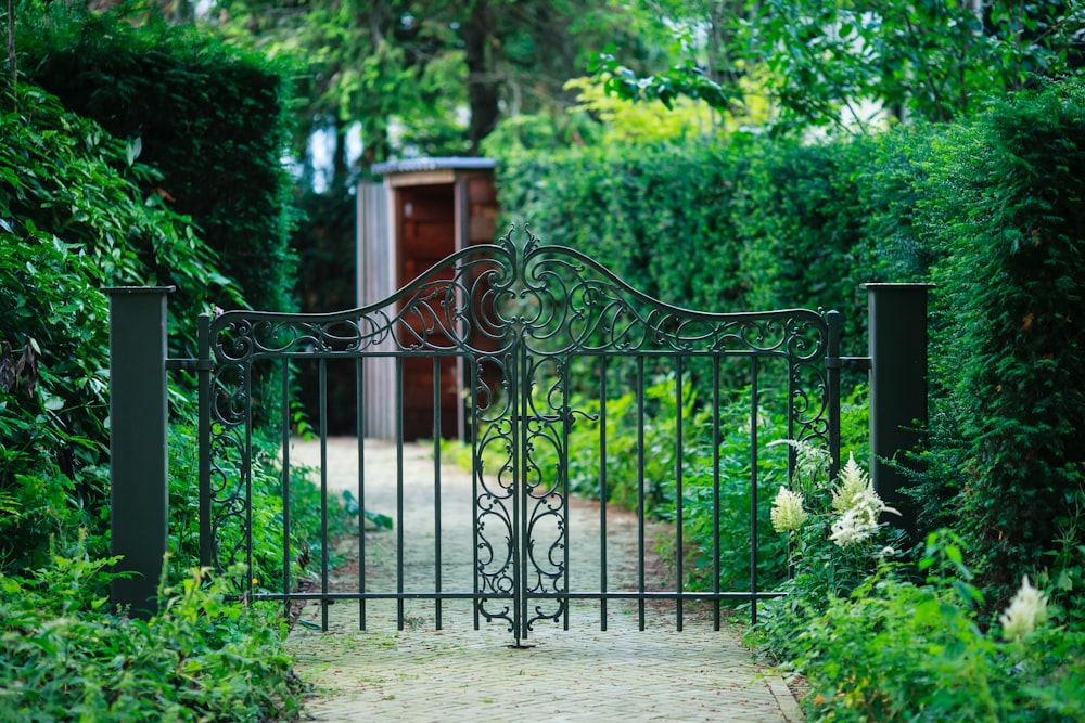 a gate in the middle of a lush green garden