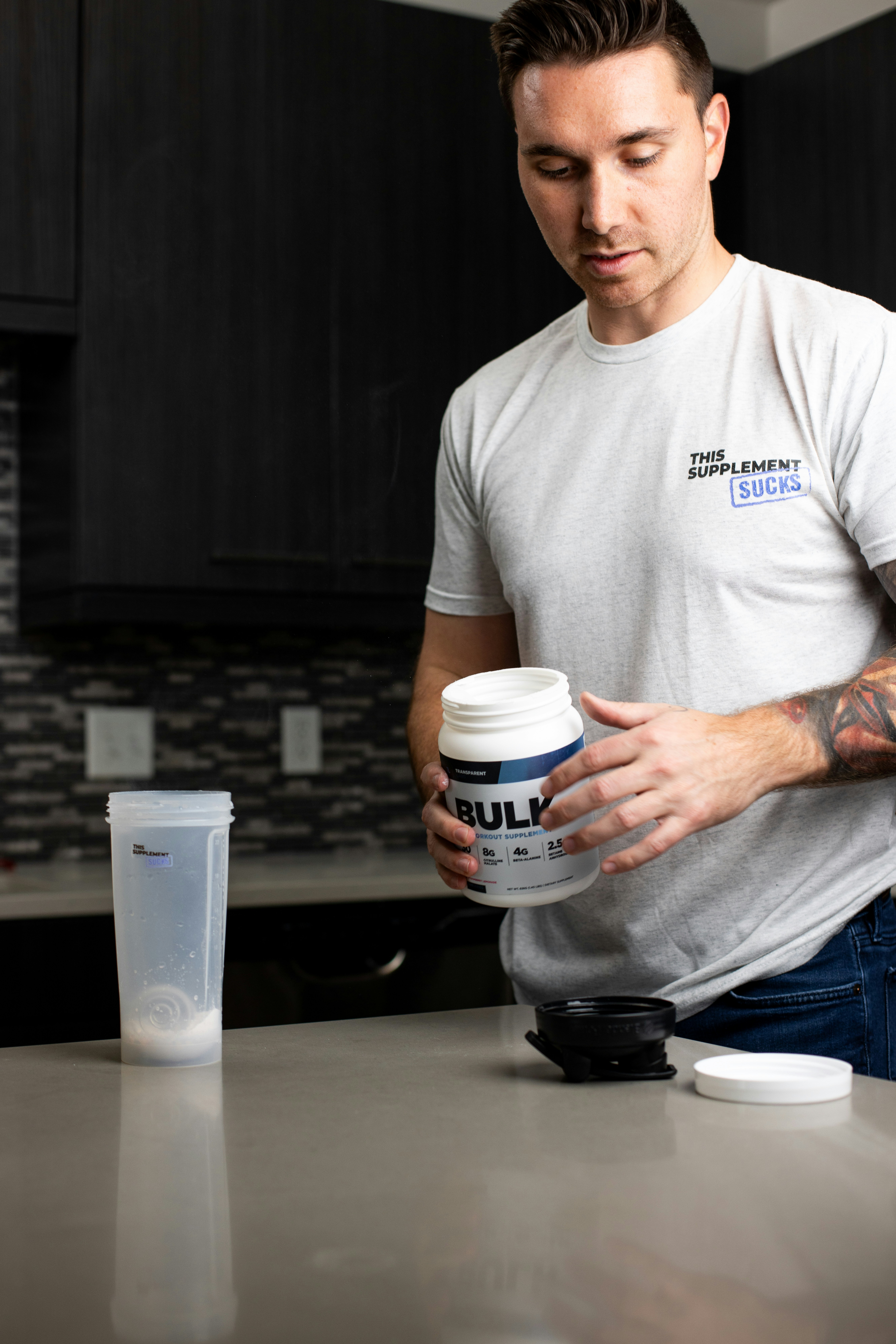 a man holding a cup of coffee in a kitchen