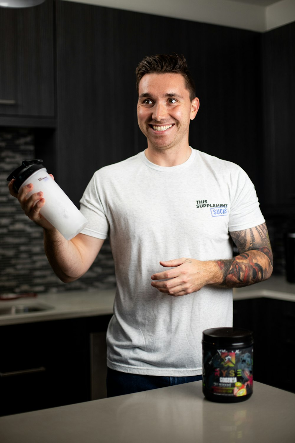 a man holding a cup of coffee in a kitchen