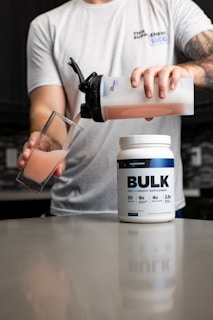 a man pouring a drink into a glass