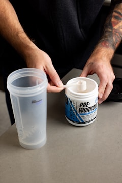 a man holding a spoon over a plastic cup