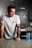 a man sitting at a kitchen counter with a drink in front of him
