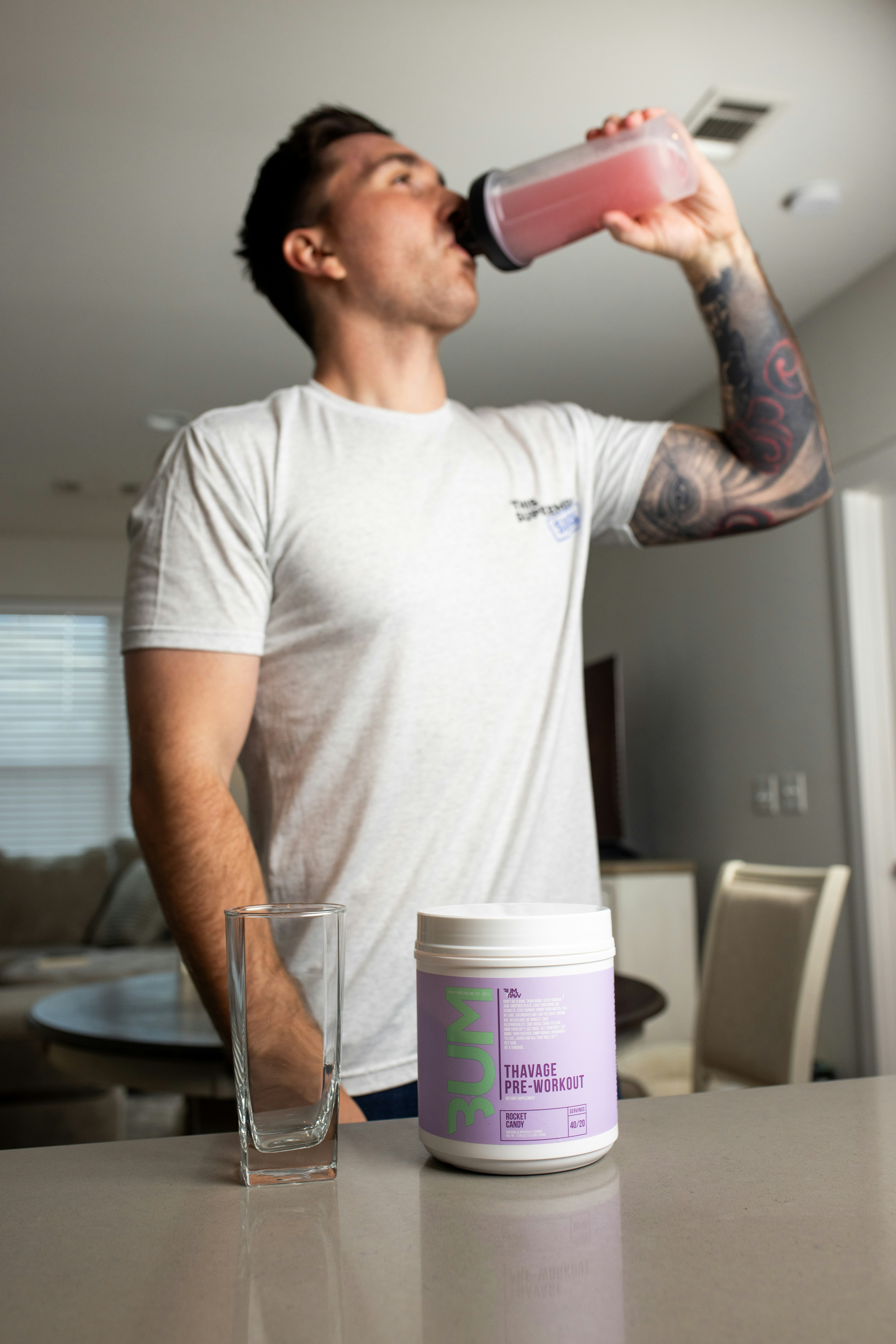 Man drinking a pre-workout shake from a shaker bottle