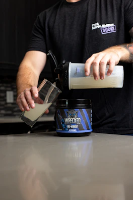 a man pours a cup of coffee into a container