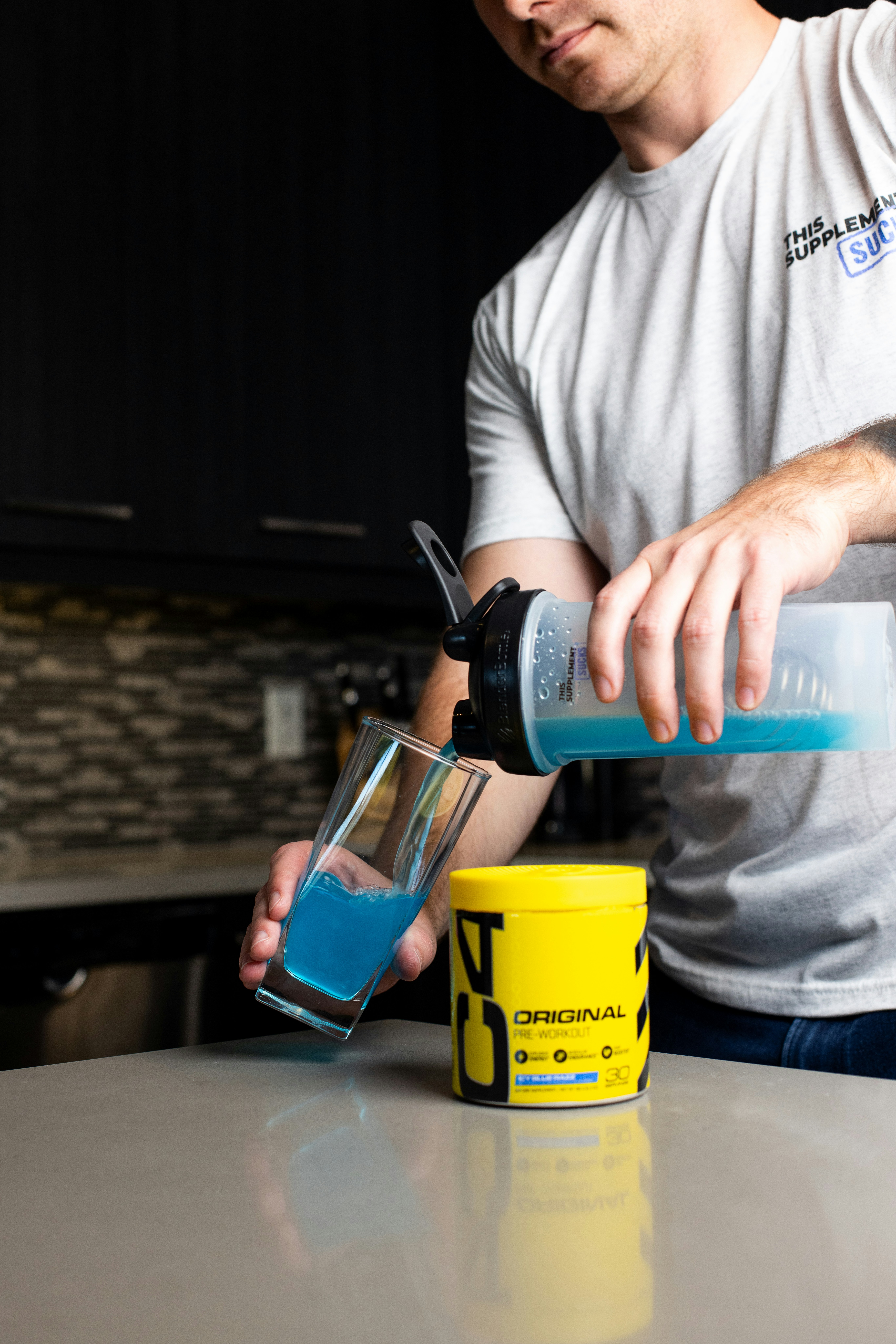 a man pouring a drink into a cup