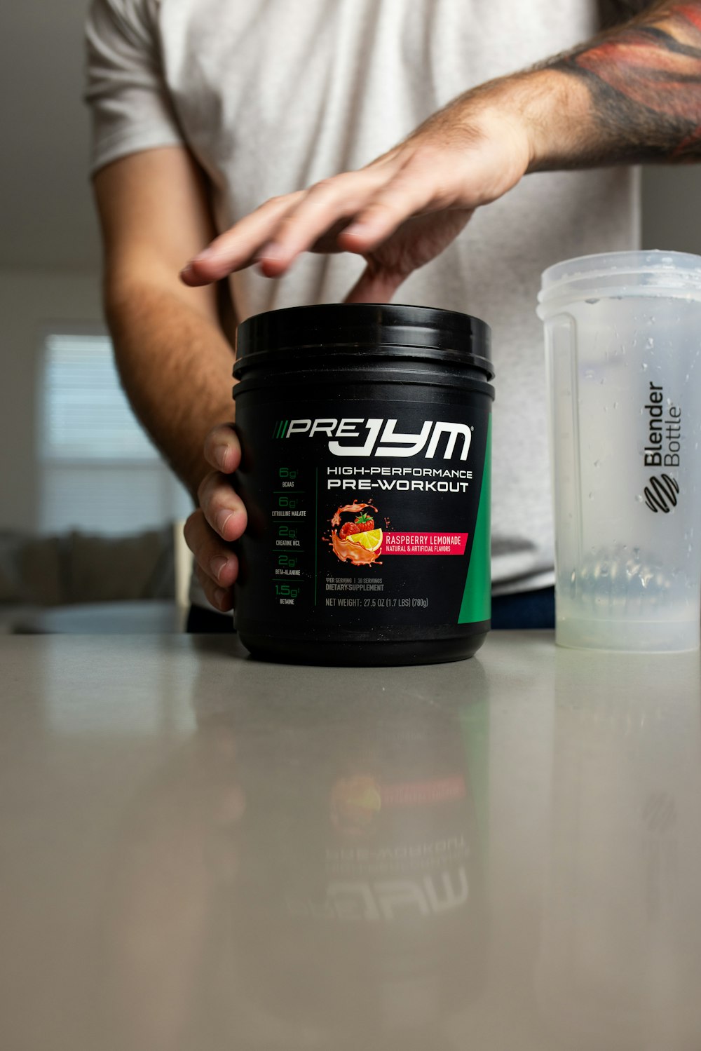 a man holding a jar of protein on top of a table