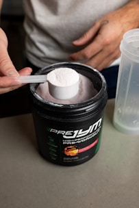 a person holding a spoon over a container of food