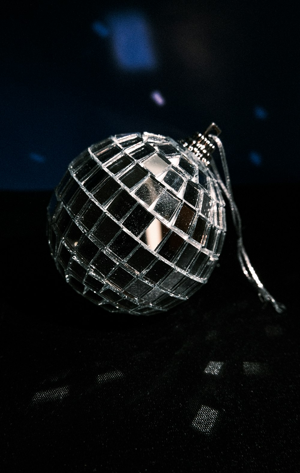 a disco ball hanging from a string on a table