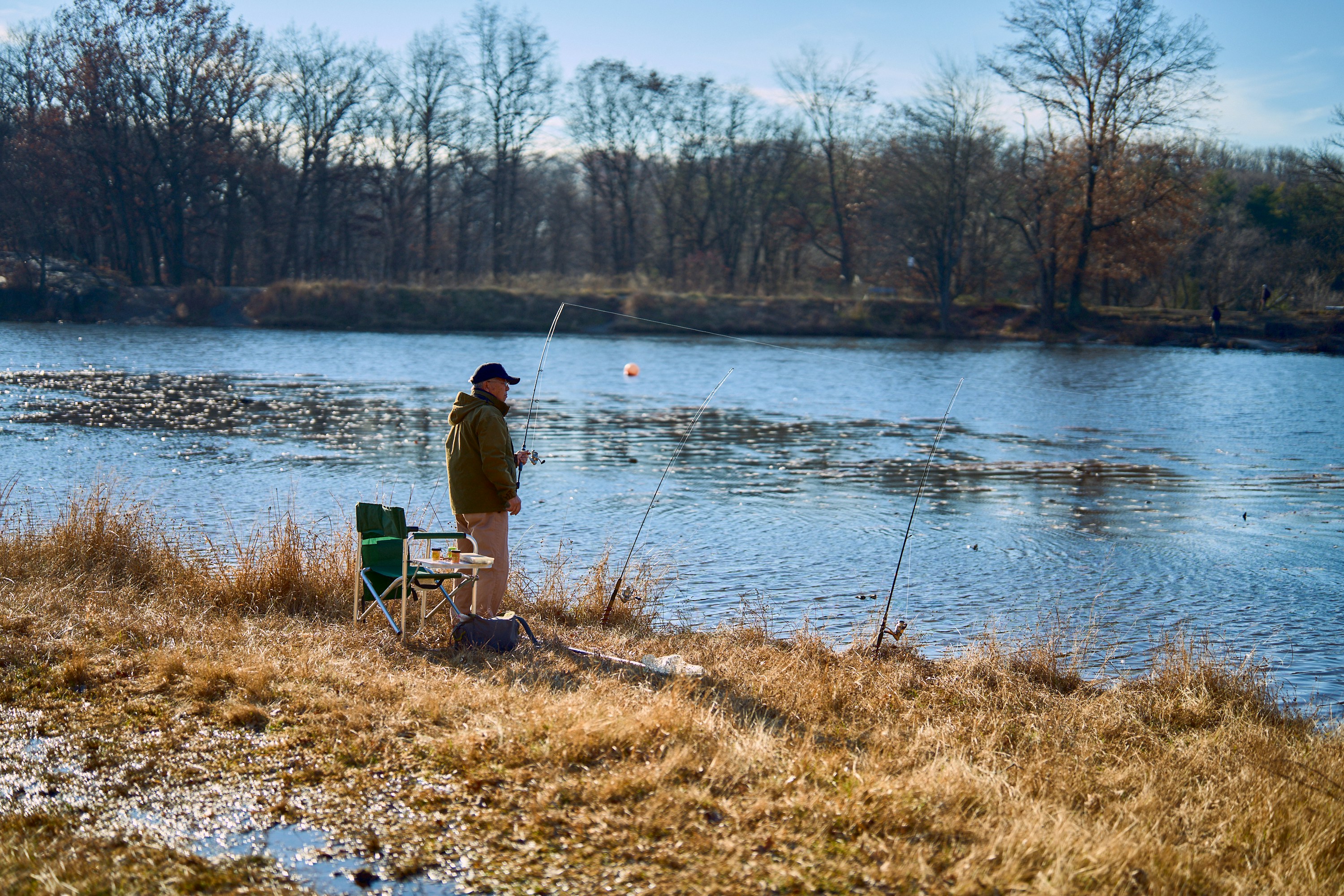 a man standing next to a body of water