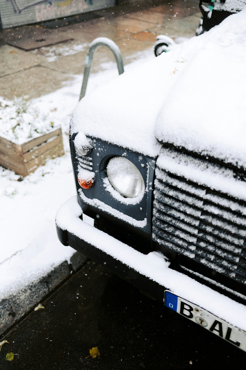 a car covered in snow parked on the side of the road