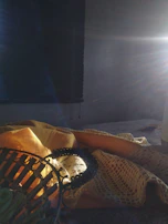 Sunlight streaming onto a table filled with colorful threads and textiles.