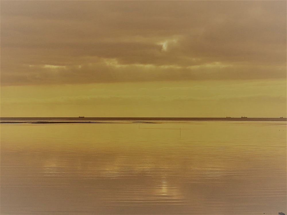 a large body of water sitting under a cloudy sky