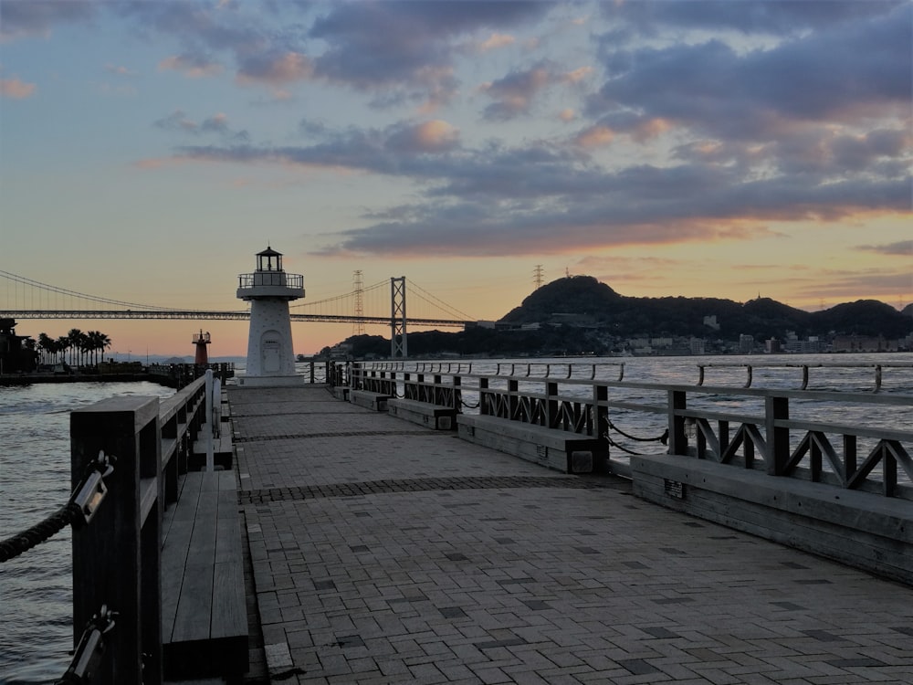 a pier with a light house in the background