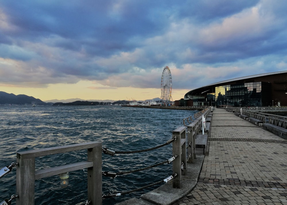 a pier with a ferris wheel in the distance