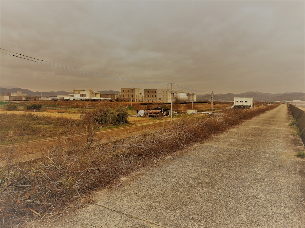 a dirt road with a building in the background