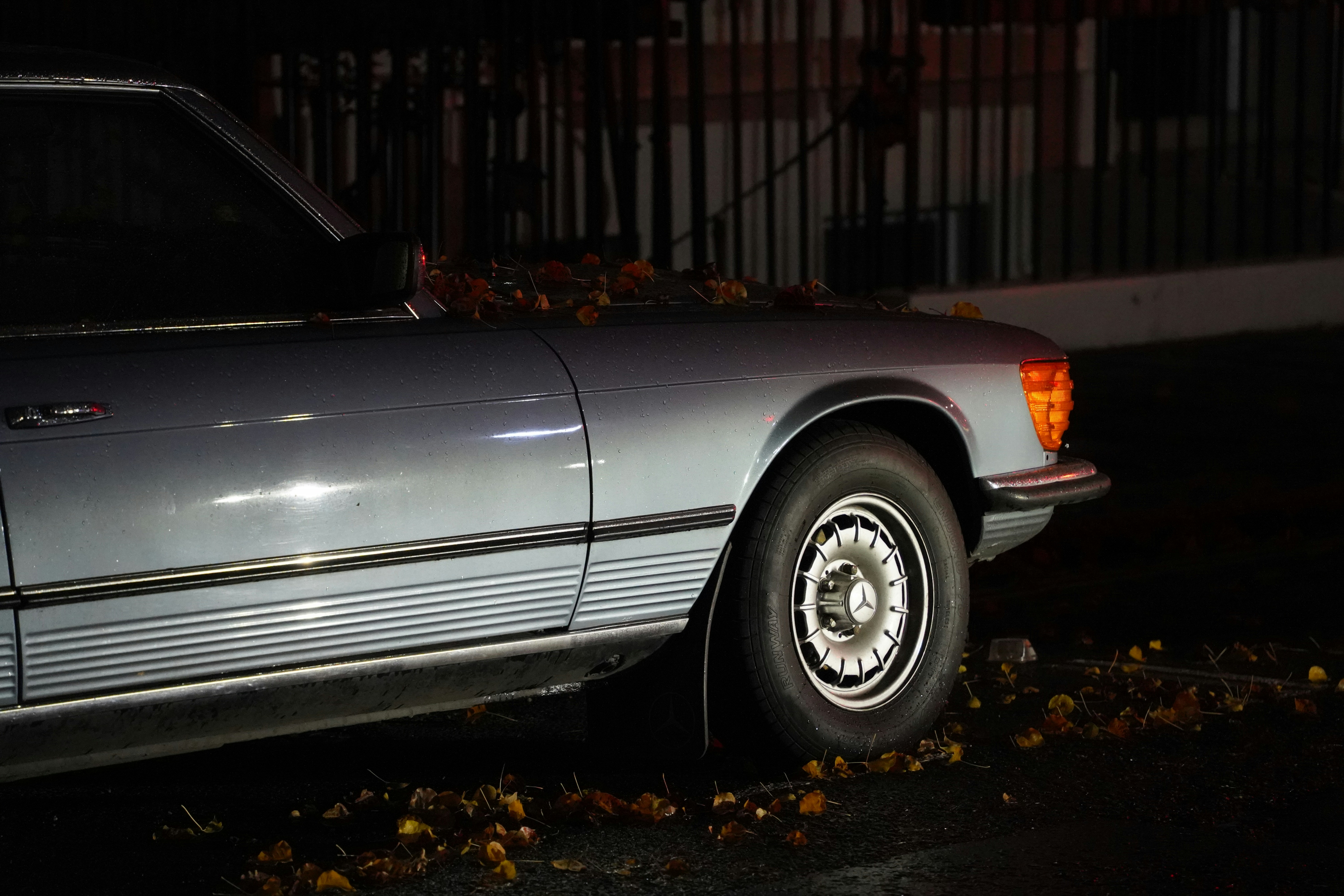 a car parked on the side of the road at night