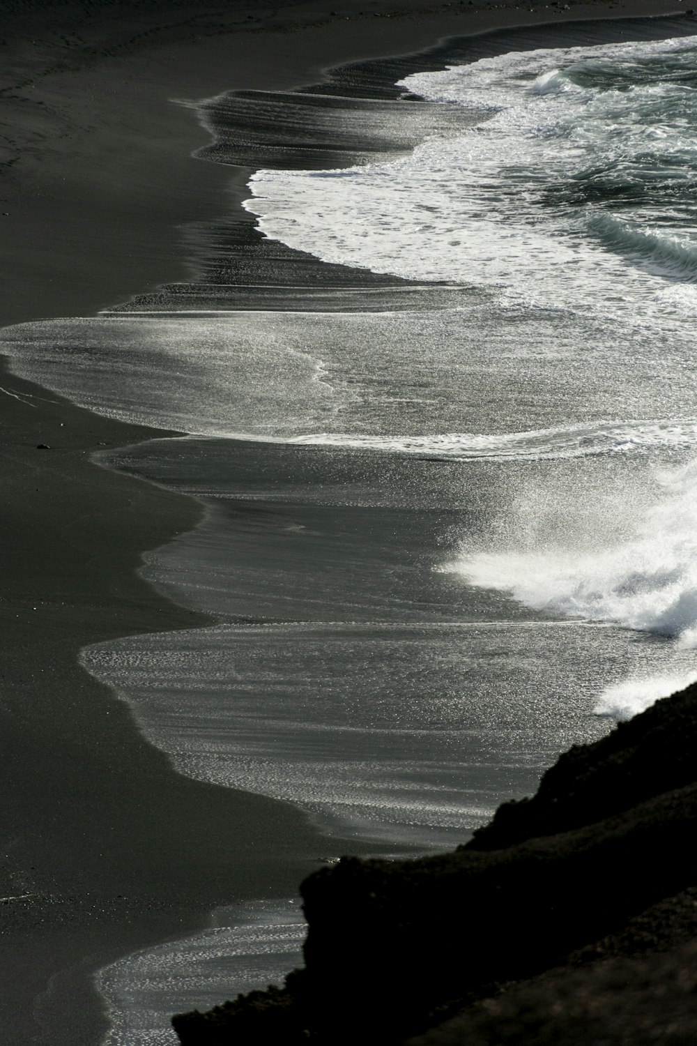 a black and white photo of the ocean and beach