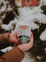A person enjoying coffee from the heated mug outdoors.