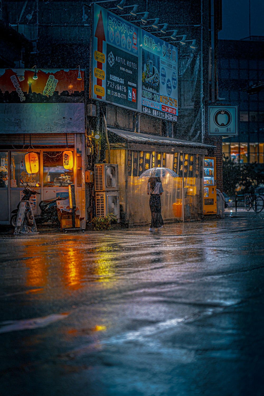 eine Person mit einem Regenschirm, die im Regen steht