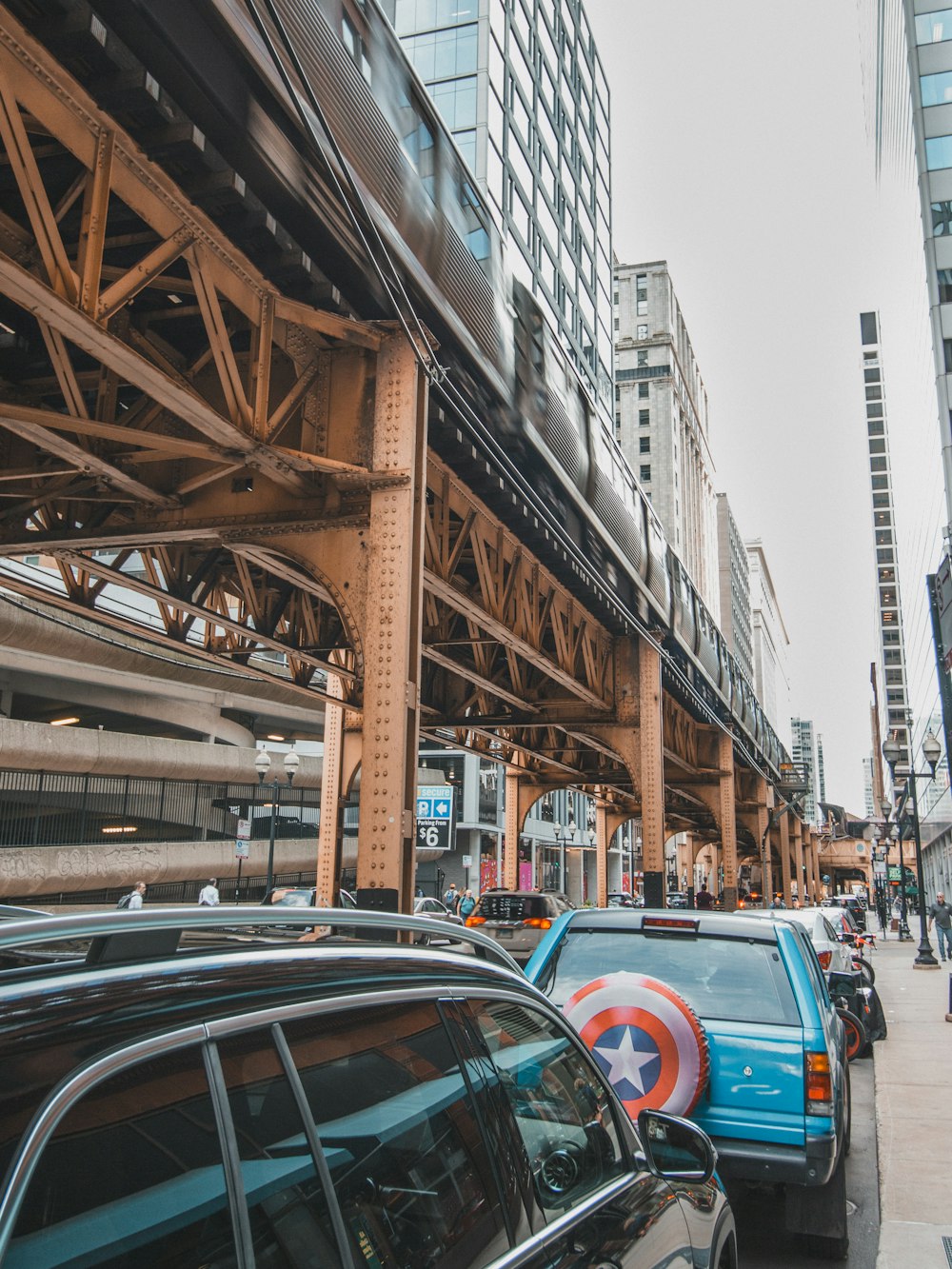 a city street filled with lots of traffic under a bridge