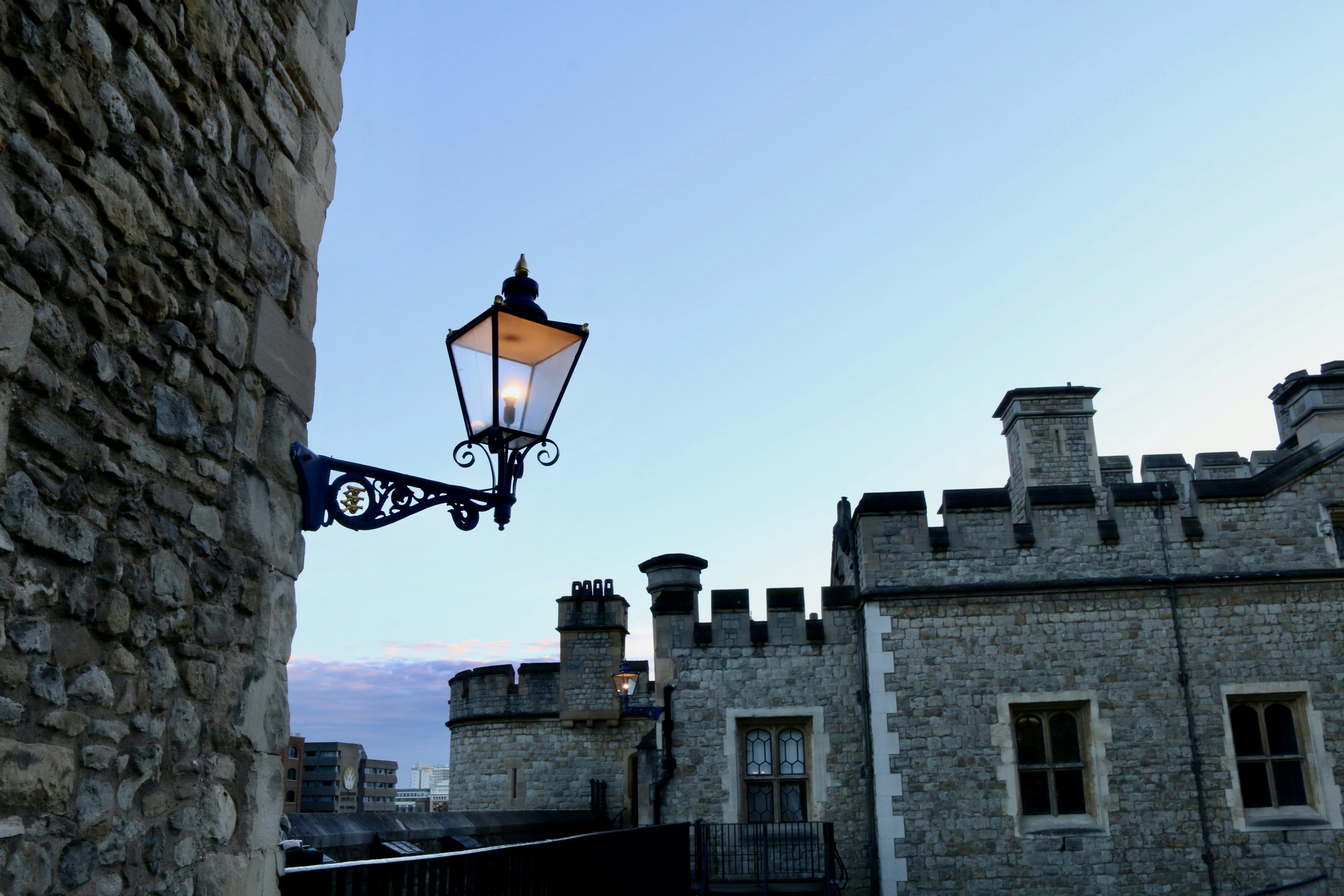 A street light hanging from the side of a stone building photo – Free ...