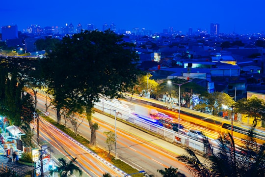 A vibrant city street at dusk with glowing lights and dynamic movement.