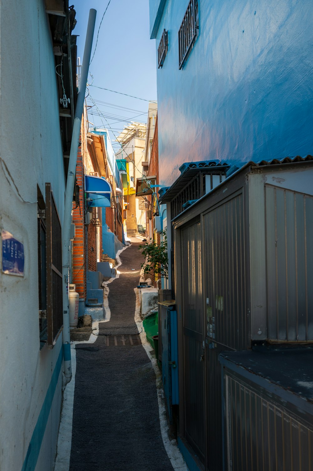 a narrow alley way with a blue building in the background