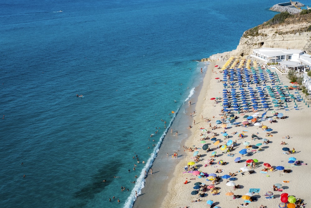 a beach filled with lots of umbrellas next to the ocean