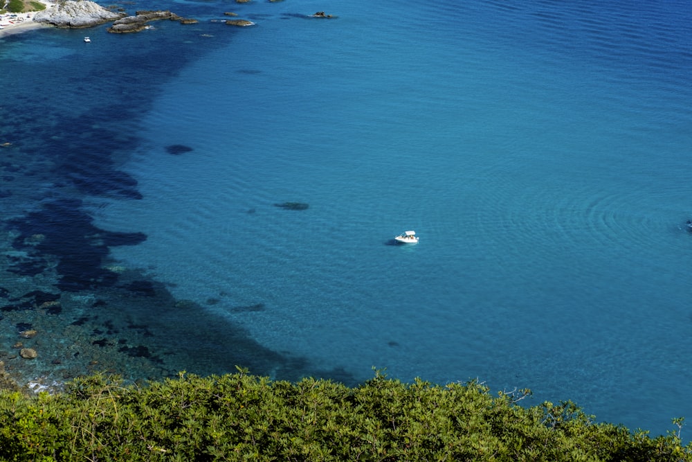 a boat floating in the blue water of a lake