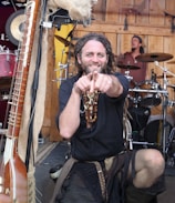 Howeird Brown performing with a quirky grin, guitar in hand.